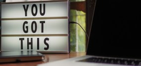 close of up computer and letter sign reading "you got this"