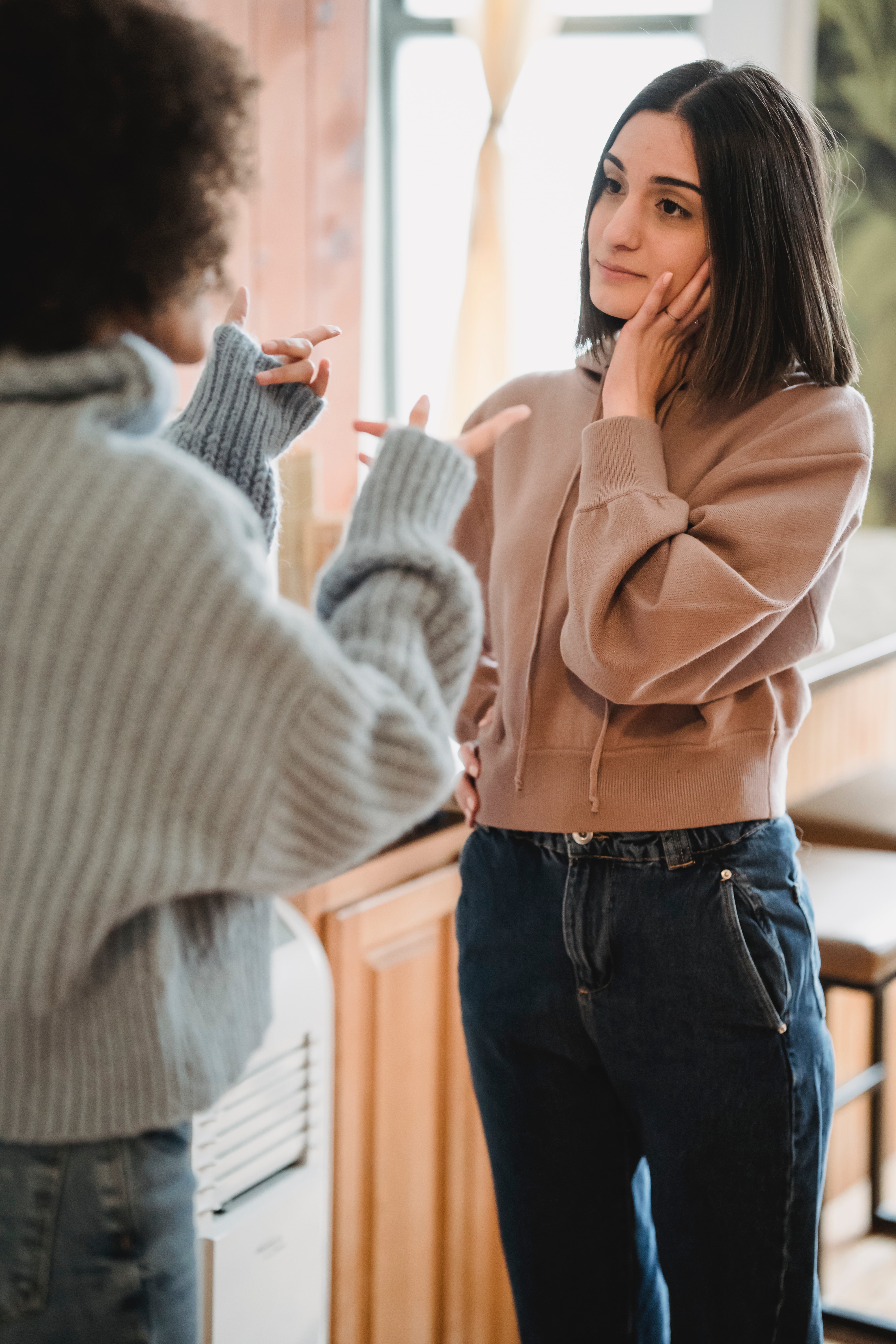 Two women in an intense discussion.  One is gesturing angrily and the other is impatient or frustrated and listening