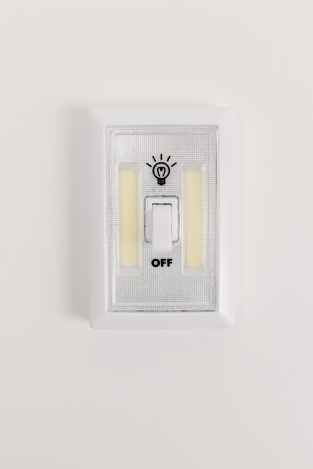 A lightswitch is powered off on a white wall.