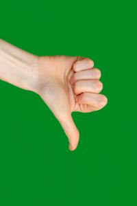 A hand makes a "thumbs down" in front of a green background.