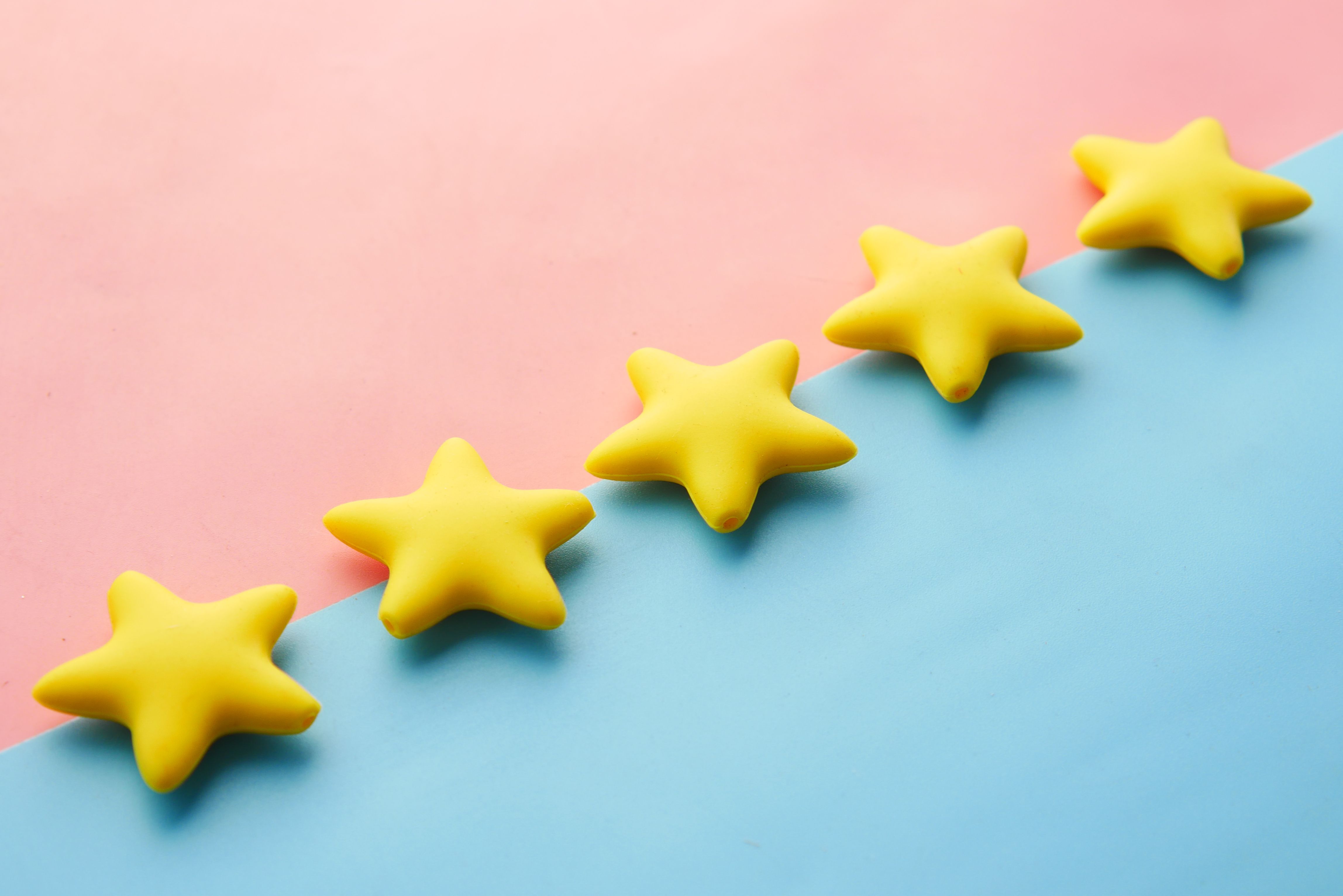 Five stars sit diagonally on a background that is split between pink and blue.